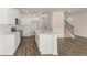 Modern kitchen with stainless steel appliances, island, and view of staircase at 310 Silver Moon Drive # 111, Loganville, GA 30052