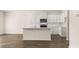 Bright and open kitchen with white cabinets, an island, and hardwood flooring at 310 Silver Moon Drive # 111, Loganville, GA 30052