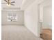 Sunlit main bedroom suite boasts a tray ceiling and adjoins a bathroom with tiled floors at 310 Silver Moon Drive # 111, Loganville, GA 30052