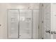 Bathroom corner shower featuring sliding glass doors, built-in shelves, and white fixtures at 310 Silver Moon Drive # 111, Loganville, GA 30052