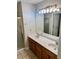 Bathroom featuring double sinks, a large mirror, and a shower with glass door at 999 Grassdale Rd, Cartersville, GA 30121