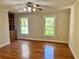Well-lit bedroom featuring hardwood floors, built-in shelving, and two windows at 999 Grassdale Rd, Cartersville, GA 30121