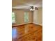 Spacious bedroom with hardwood floors, ceiling fan, and sunlit windows at 999 Grassdale Rd, Cartersville, GA 30121