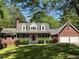 Charming brick home with a red door, dormer windows, and a two-car garage surrounded by a green lawn at 999 Grassdale Rd, Cartersville, GA 30121