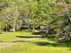 A lovely brick home with dormer windows is nestled among trees and a long driveway over a green lawn at 999 Grassdale Rd, Cartersville, GA 30121
