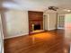 Open living room with gleaming hardwood floors and a brick fireplace with a gold accent at 999 Grassdale Rd, Cartersville, GA 30121