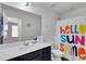 Bright bathroom with dark cabinets, toilet, mirror and a colorful shower curtain at 1929 Millstream Holw, Conyers, GA 30012