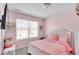 Soft pink bedroom featuring a white bed frame, fluffy pillows, and natural light at 1929 Millstream Holw, Conyers, GA 30012