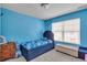 Vibrant blue bedroom featuring a navy blue bedframe, and natural light from the window at 1929 Millstream Holw, Conyers, GA 30012