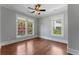 Bedroom with large windows showcasing views of mature trees, hardwood floors, and neutral walls at 22 The Prado Ne, Atlanta, GA 30309