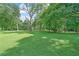 Expansive green field surrounded by mature trees, offering a serene and open space at 22 The Prado Ne, Atlanta, GA 30309