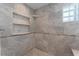 Shower stall featuring marble tiling, a built-in shelf, and glass-block window at 22 The Prado Ne, Atlanta, GA 30309