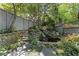 Captivating backyard water feature surrounded by stone walls and lush landscaping, a serene oasis at 22 The Prado Ne, Atlanta, GA 30309