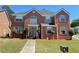 Charming two-story brick home with a well-manicured lawn, complemented by trimmed bushes at 2347 Fawn Hollow Ct, Duluth, GA 30096