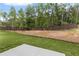 Large backyard featuring green grass, wood fence, and mature trees, creating a private outdoor space at 6100 Marigold Way, Atlanta, GA 30349