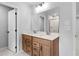 Bathroom with dual sinks, wood vanity, and modern light fixtures at 6100 Marigold Way, Atlanta, GA 30349