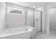 Bathroom with a tub, glass-enclosed shower, and marble accents at 6100 Marigold Way, Atlanta, GA 30349
