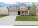 Inviting two-story brick home featuring a well-manicured lawn and an attached two-car garage at 6100 Marigold Way, Atlanta, GA 30349
