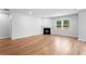 Bright living room with hardwood floors, a fireplace, and large windows overlooking the backyard at 6100 Marigold Way, Atlanta, GA 30349
