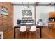 Open-concept dining room featuring modern furnishings, exposed brick, and an open kitchen view at 1596 Cleveland Ave # 204, Atlanta, GA 30344