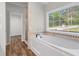 Bright bathroom featuring a soaking tub under a window and a separate shower at 280 Old Carrollton Rd, Carrollton, GA 30116