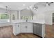 Open-concept kitchen featuring stainless steel appliances, white cabinets, and hardwood floors at 280 Old Carrollton Rd, Carrollton, GA 30116