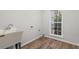 Bright laundry room with a utility sink, wood-look floors, and a window offering natural light at 280 Old Carrollton Rd, Carrollton, GA 30116