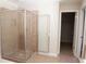 Bathroom featuring tile shower with glass door, tile flooring, and doorway to walk in closet at 5122 Micaela Way, Duluth, GA 30096