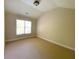 Cozy bedroom with neutral-colored walls and carpet flooring, illuminated by a window at 5122 Micaela Way, Duluth, GA 30096