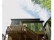 Back exterior view of home with stairs leading up to a deck, large windowed porch, and green siding at 5122 Micaela Way, Duluth, GA 30096