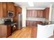 Well-lit eat-in kitchen featuring hardwood floors, dark wood cabinets, and stainless steel appliances at 5122 Micaela Way, Duluth, GA 30096