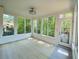 Bright sunroom with beautiful outdoor views, white trim, and light hardwood floors at 5122 Micaela Way, Duluth, GA 30096