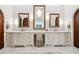 Luxurious bathroom with marble counters, decorative mirrors, elegant lighting, and custom cabinets at 811 Flathead Pass, Suwanee, GA 30024