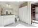 Bright bathroom with white vanity, shower with white curtain, and walk-in closet at 811 Flathead Pass, Suwanee, GA 30024