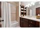 Well-lit bathroom with dark wood cabinets, tiled shower, and a large mirror above the vanity at 811 Flathead Pass, Suwanee, GA 30024
