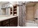 Elegant bathroom features dark wood cabinets, tiled shower, and beautiful patterned shower curtain at 811 Flathead Pass, Suwanee, GA 30024