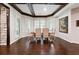 Bright dining room featuring a dark wood floor, white trim, plantation shutters, and elegant artwork at 811 Flathead Pass, Suwanee, GA 30024