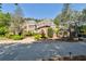 Beautifully landscaped home featuring a circular driveway and mature trees at 811 Flathead Pass, Suwanee, GA 30024
