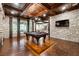 Large game room with stone walls, hardwood floors, pool table, and wood-coffered ceilings at 811 Flathead Pass, Suwanee, GA 30024