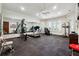 Well-equipped home gym with exercise machines, free weights, mirrors and natural light at 811 Flathead Pass, Suwanee, GA 30024