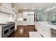 Elegant kitchen with stainless steel range, farmhouse sink, and white cabinets, and hardwood floors at 811 Flathead Pass, Suwanee, GA 30024