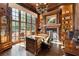 Wood-paneled office with a large window, built-in shelves, and a classic chandelier at 811 Flathead Pass, Suwanee, GA 30024