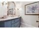Elegant powder room featuring a blue vanity, decorative mirror, and marble countertop at 811 Flathead Pass, Suwanee, GA 30024