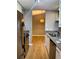 Galley kitchen with stainless steel appliances, granite countertops, and hardwood floors at 310 Warm Springs Cir, Roswell, GA 30075