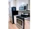 Close up of black and stainless steel kitchen appliances, including microwave and electric oven at 310 Warm Springs Cir, Roswell, GA 30075