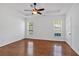 Spacious bedroom with hardwood floors, tray ceiling, and natural light from two windows, creating a serene atmosphere at 4309 Milford Pl, Hoschton, GA 30548