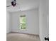 Bright bedroom featuring neutral carpet, and a window offering outdoor views at 4309 Milford Pl, Hoschton, GA 30548