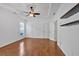 Spacious bedroom featuring hardwood floors, a tray ceiling with fan, and white trim at 4309 Milford Pl, Hoschton, GA 30548