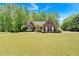 Well-kept brick home with a lush front yard, accented by mature trees and dark window shutters at 4309 Milford Pl, Hoschton, GA 30548