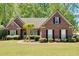 Charming brick home with manicured lawn, complemented by mature trees and classic black shutters at 4309 Milford Pl, Hoschton, GA 30548